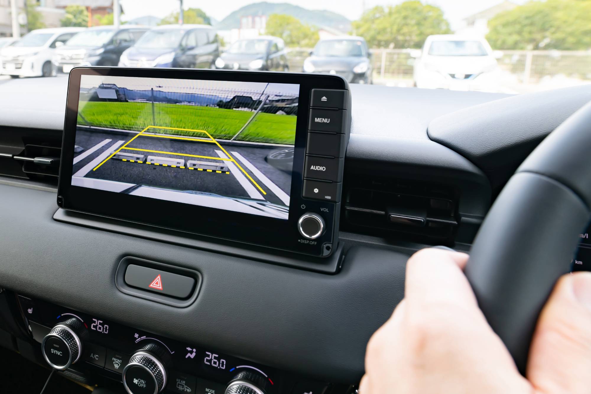 車内でバックカメラの映像を見ながらハンドルを握る運転手