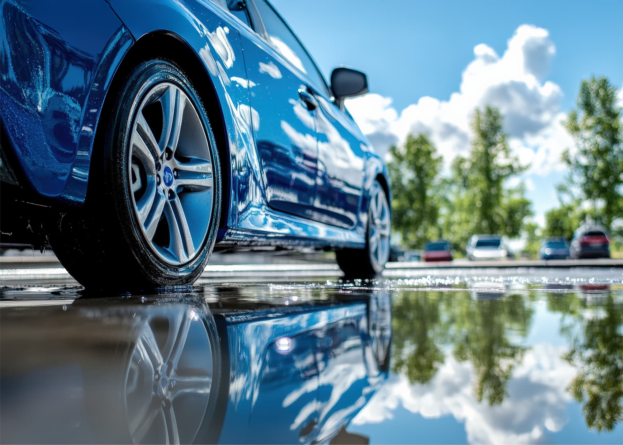 濡れたアスファルトに映る青い車の美しい反射