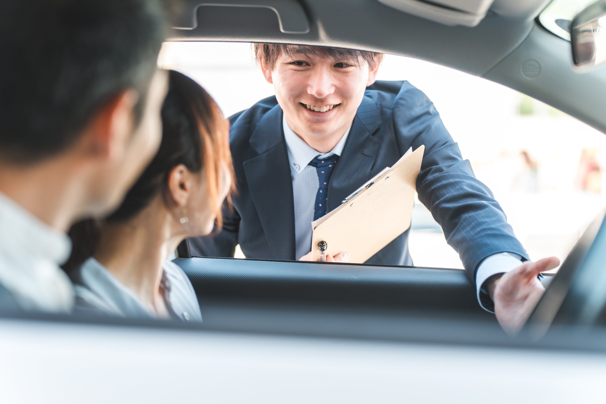 顧客に車を説明する車の担当スタッフ