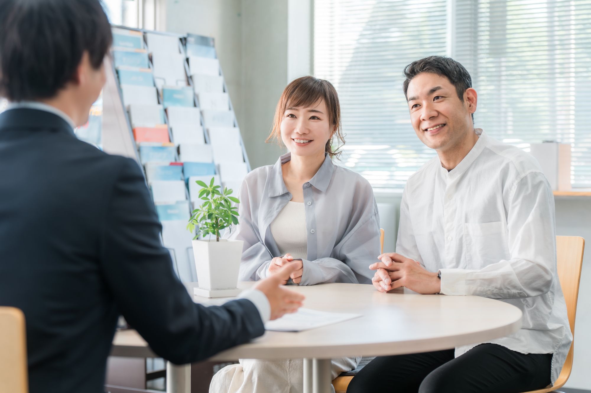 若いカップルがオフィスで説明をうけている